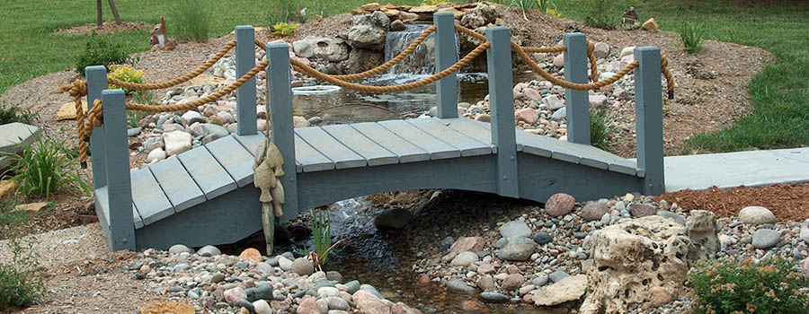 Wooden bridge over a creek with landscaping