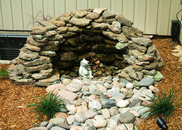 River rock water feature with ornamental frog